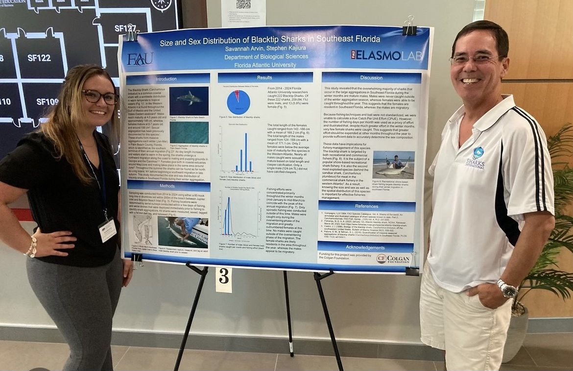 Savannah Arvin and Dr. Stephen Kajiura smile next to their research poster at the undergraduate symposium