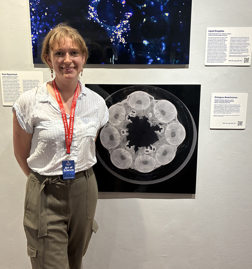 Natasha Ahrweiler poses with her honorable mention submission depicting a micro-CT image cross-section directly below the head. The unaltered crown of eight arms and their corresponding nerve cords are visible.
