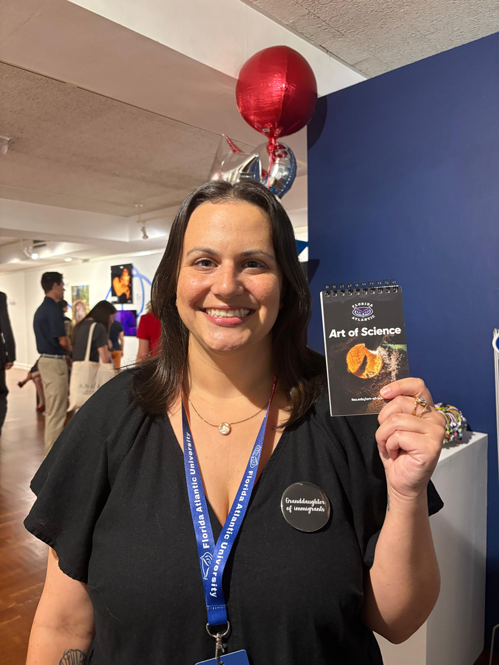   Second-place winner, Gabby Carvajal, poses with a small notebook with her submission printed on the cover! Her photo shows how FAU Marine Lab scientists monitor sea turtle development in the lab by "candling" the eggs. With a flashlight, one can see development in action from the blood supply to the close-up of the flipper.